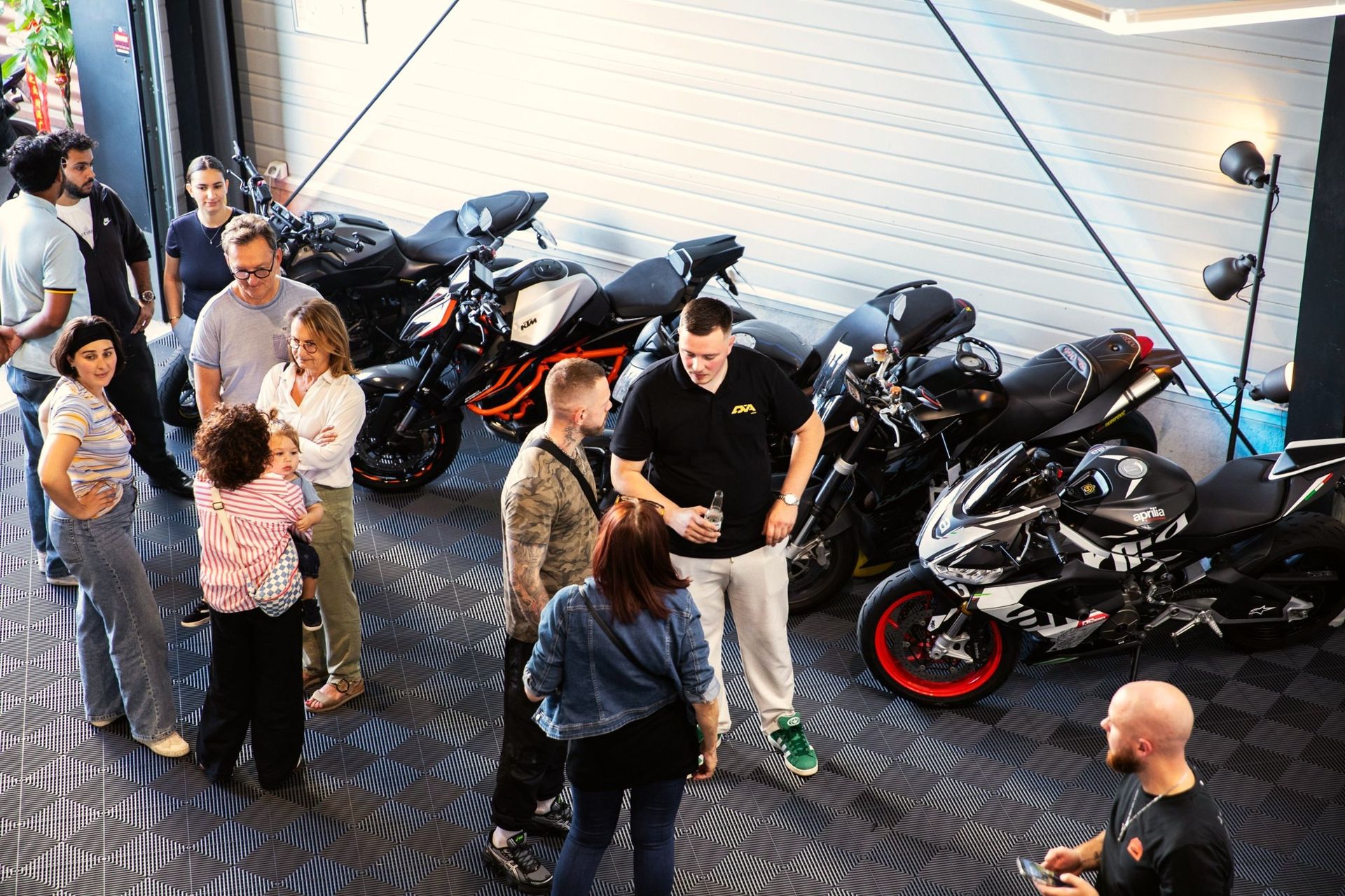 Échanges entre invités et associés devant les motos exposées